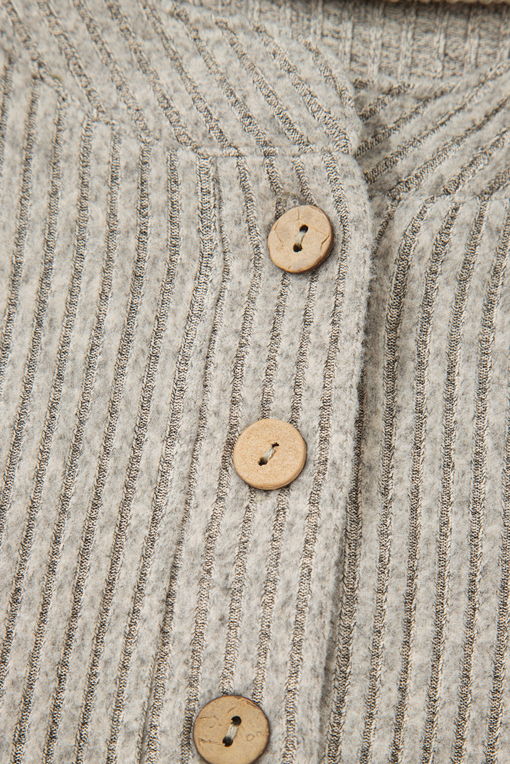 Close-up of a textured fabric with buttons on a garment