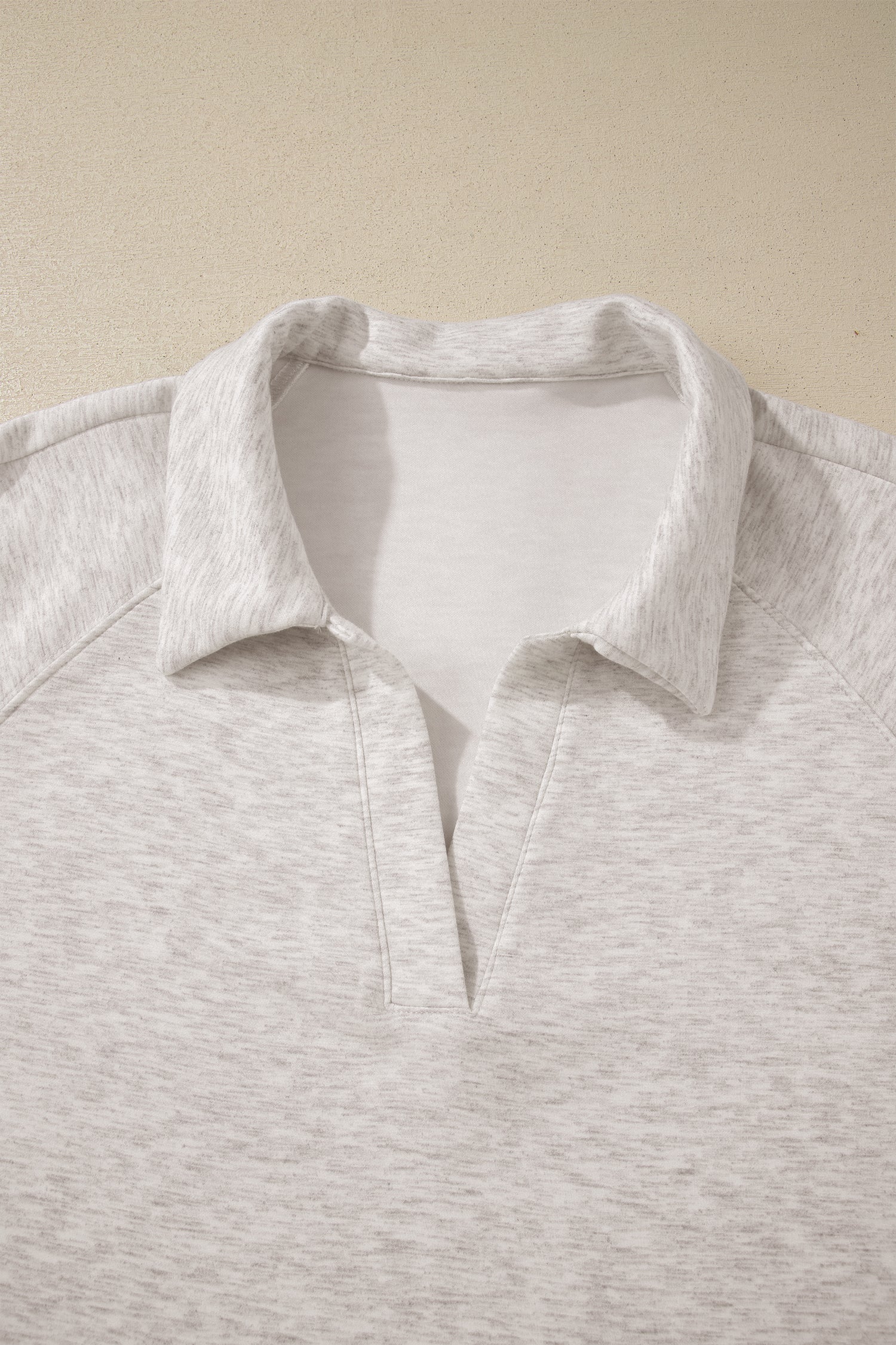 Light gray polo shirt on a beige background