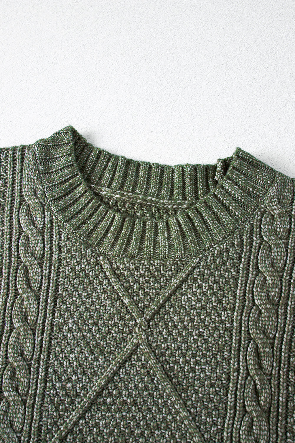 Close-up of a green cable knit sweater dress detail