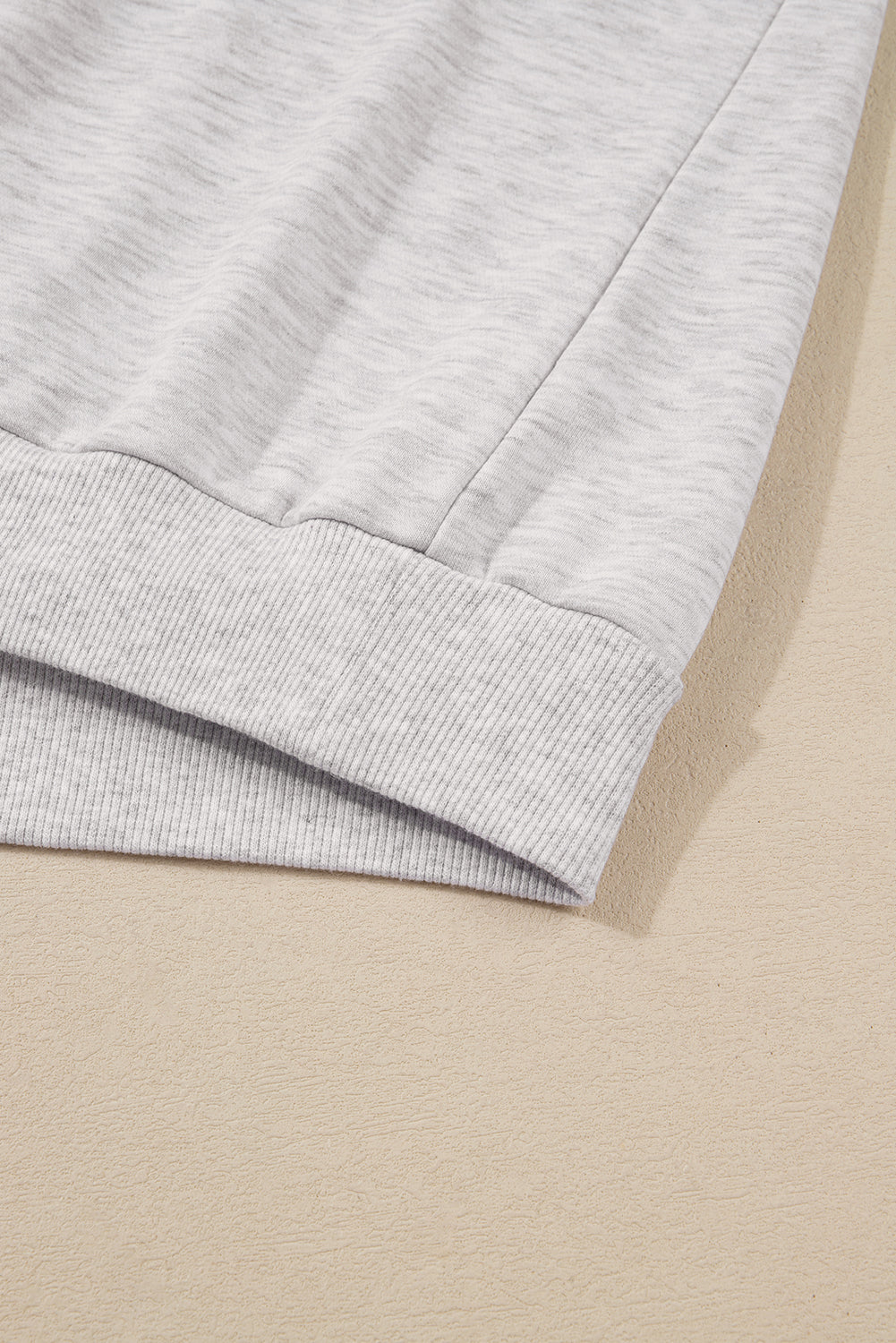 Close-up of a light gray fabric edge on a beige background