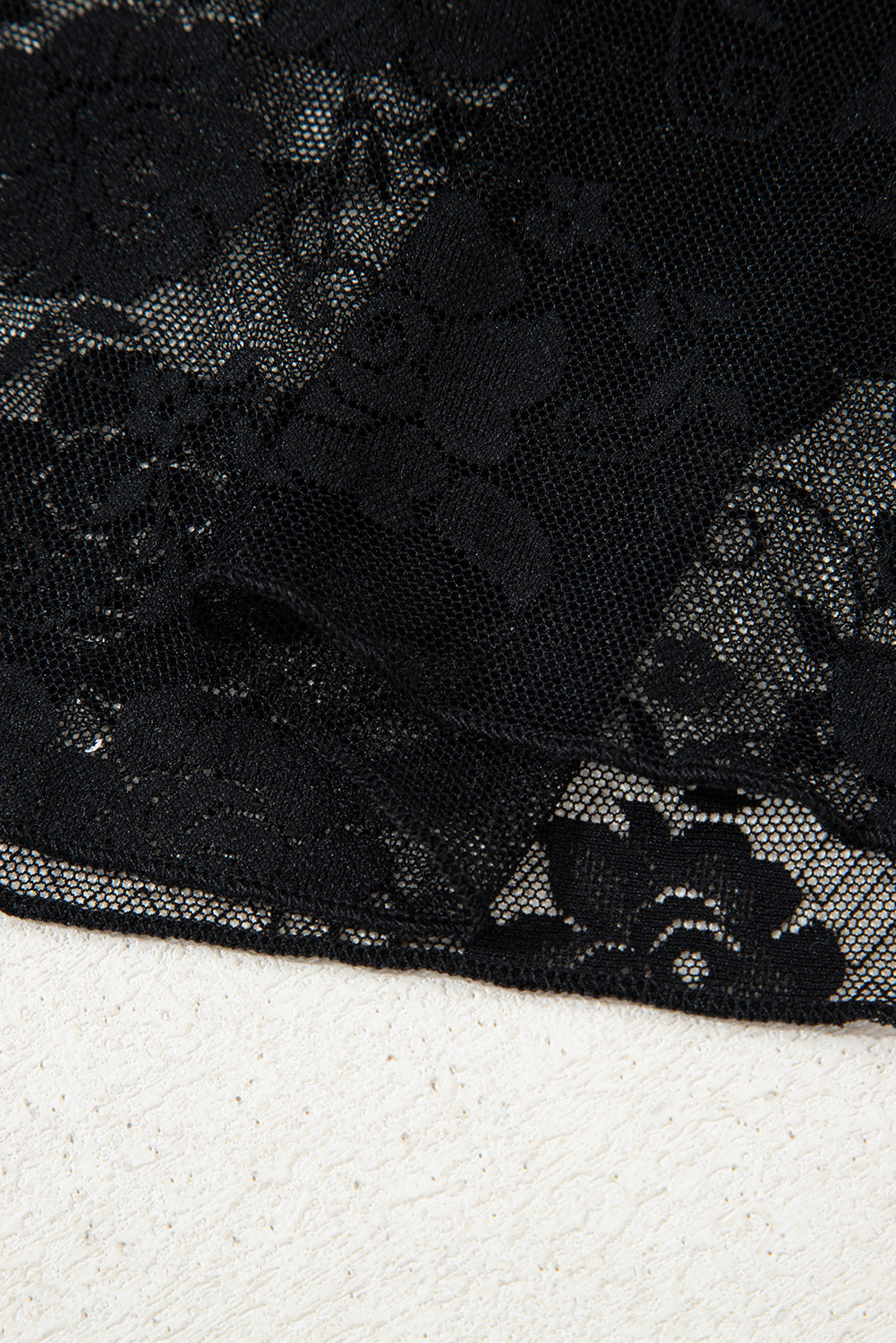 Black lace fabric on a white background