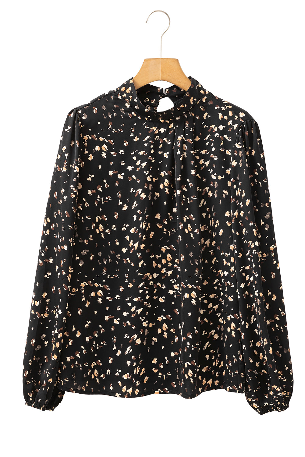 Black blouse with beige pattern on a wooden hanger against a white background