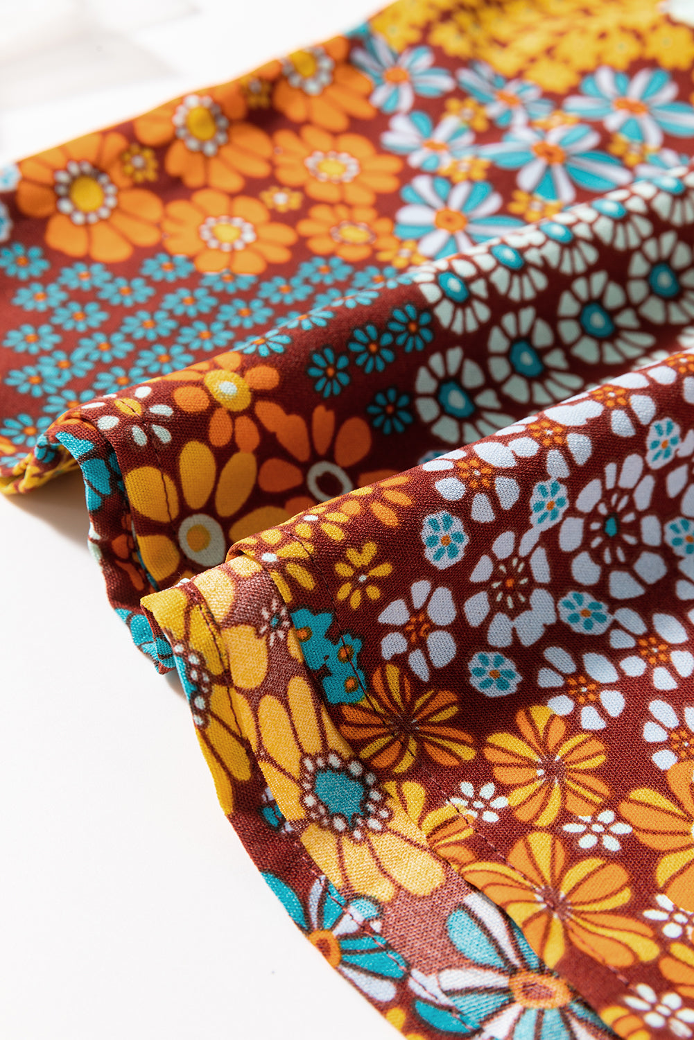 Three floral fabric swatches in brown, orange, and blue on a white background