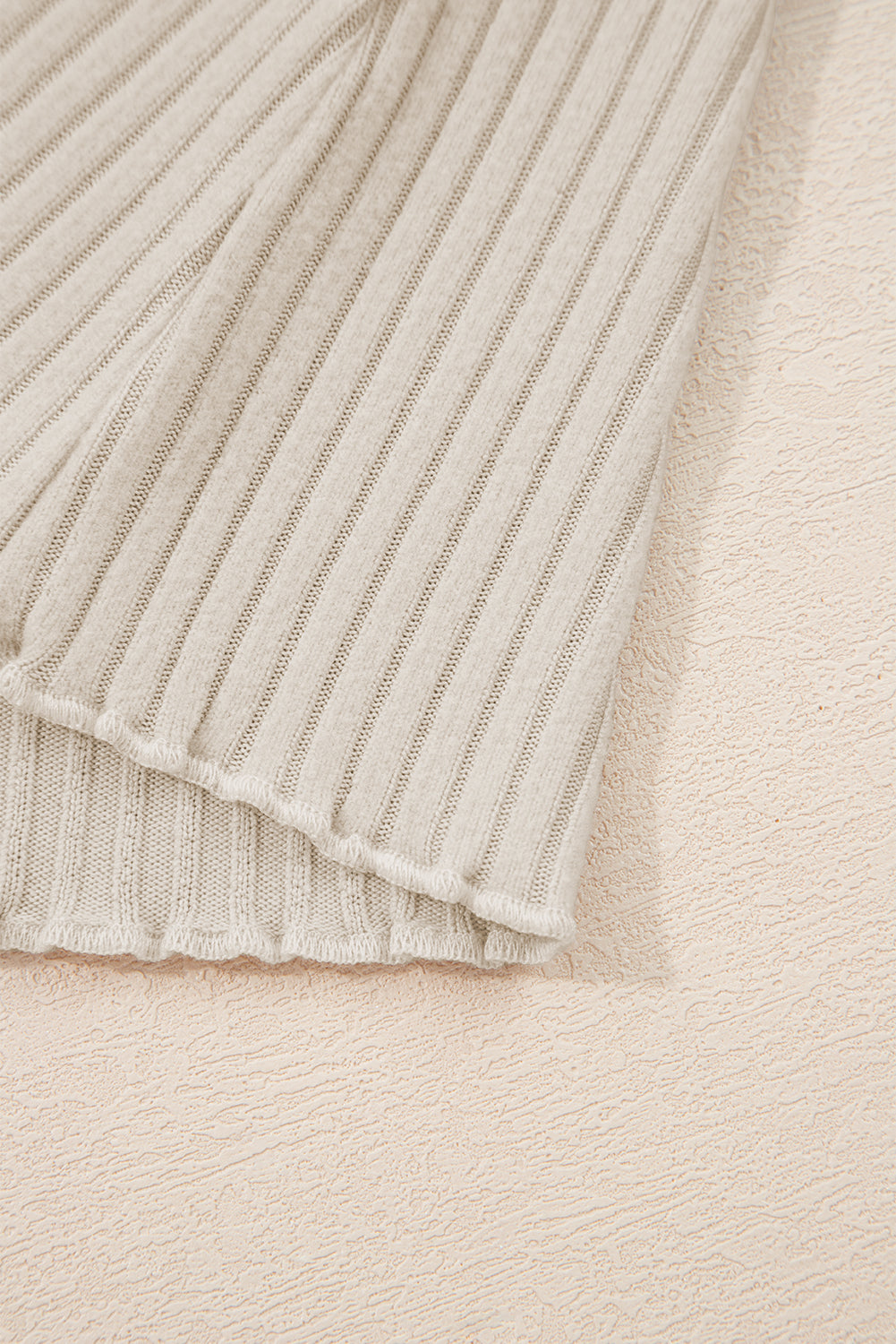 Close-up of a textured beige fabric with a ribbed pattern.