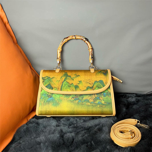 Handbag with bamboo handle and scenic design on a textured surface