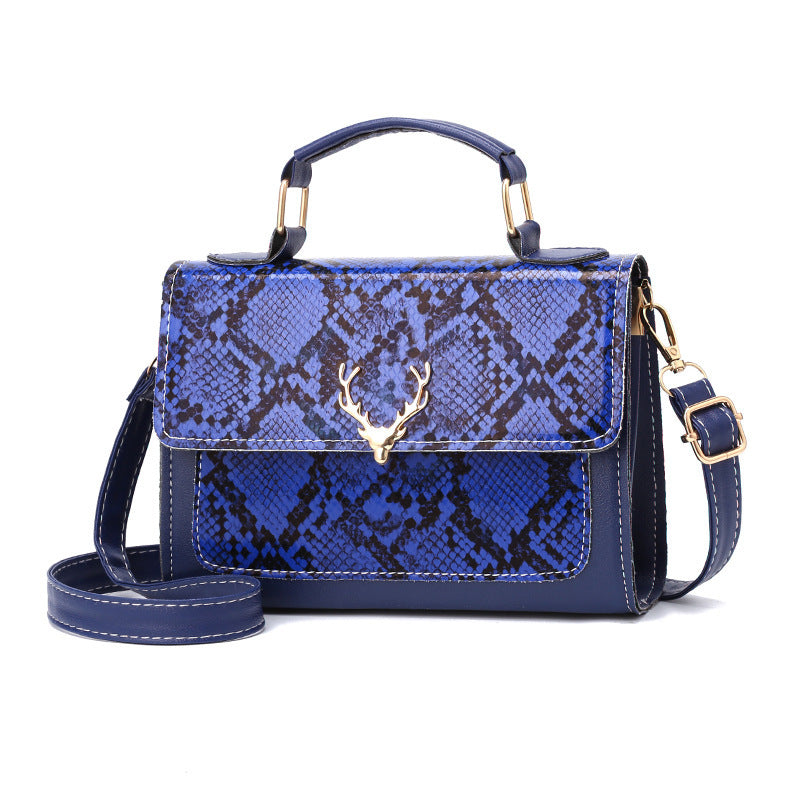 Blue snake print handbag with gold accents on a white background