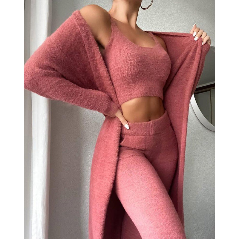 Person wearing a pink outfit with a long cardigan against a neutral background