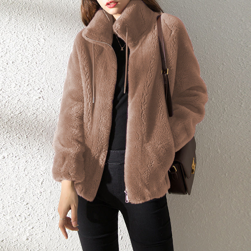 Person wearing a brown textured jacket against a light gray background