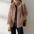 Person wearing a brown textured jacket against a light gray background