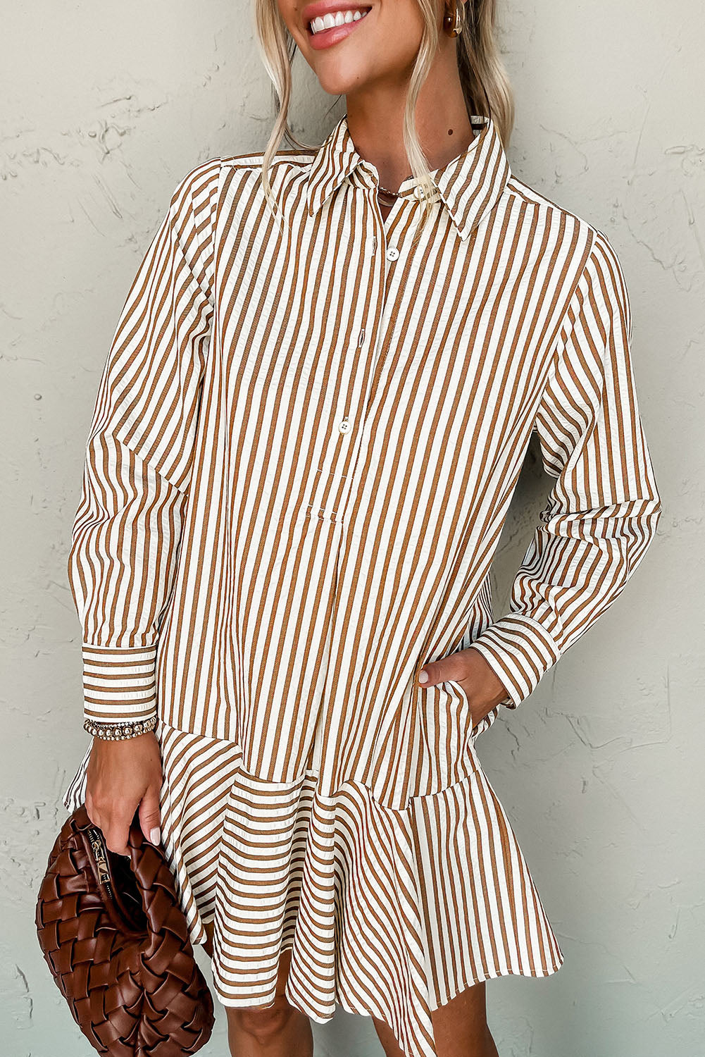Close-up of a model in a brown and white striped dress with a flared skirt and button-down detail