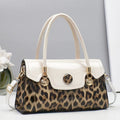 Handbag with leopard print and white accents on a gray background