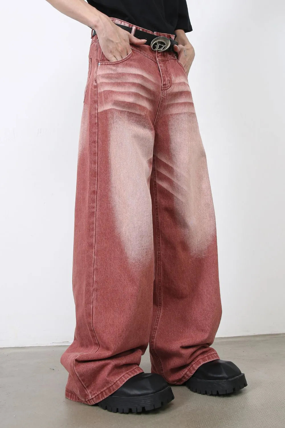 Person wearing wide-leg red rust acid washed jeans side view
