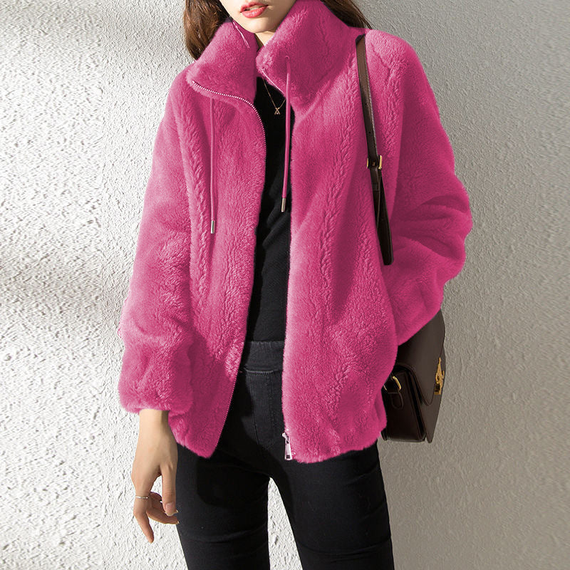 Person wearing a bright pink jacket against a neutral background