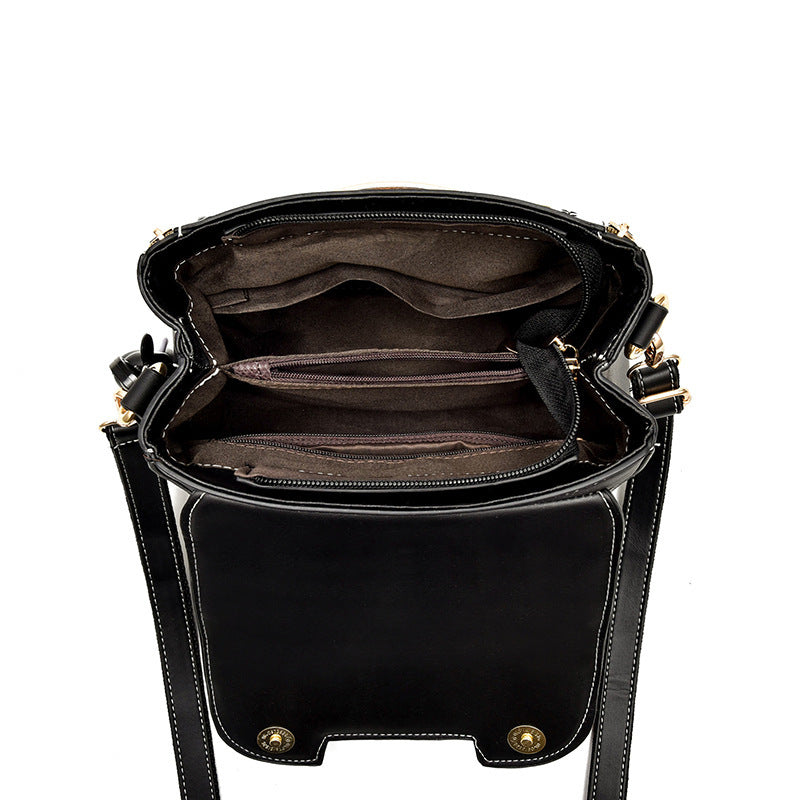 Black handbag with gold accents on a white background