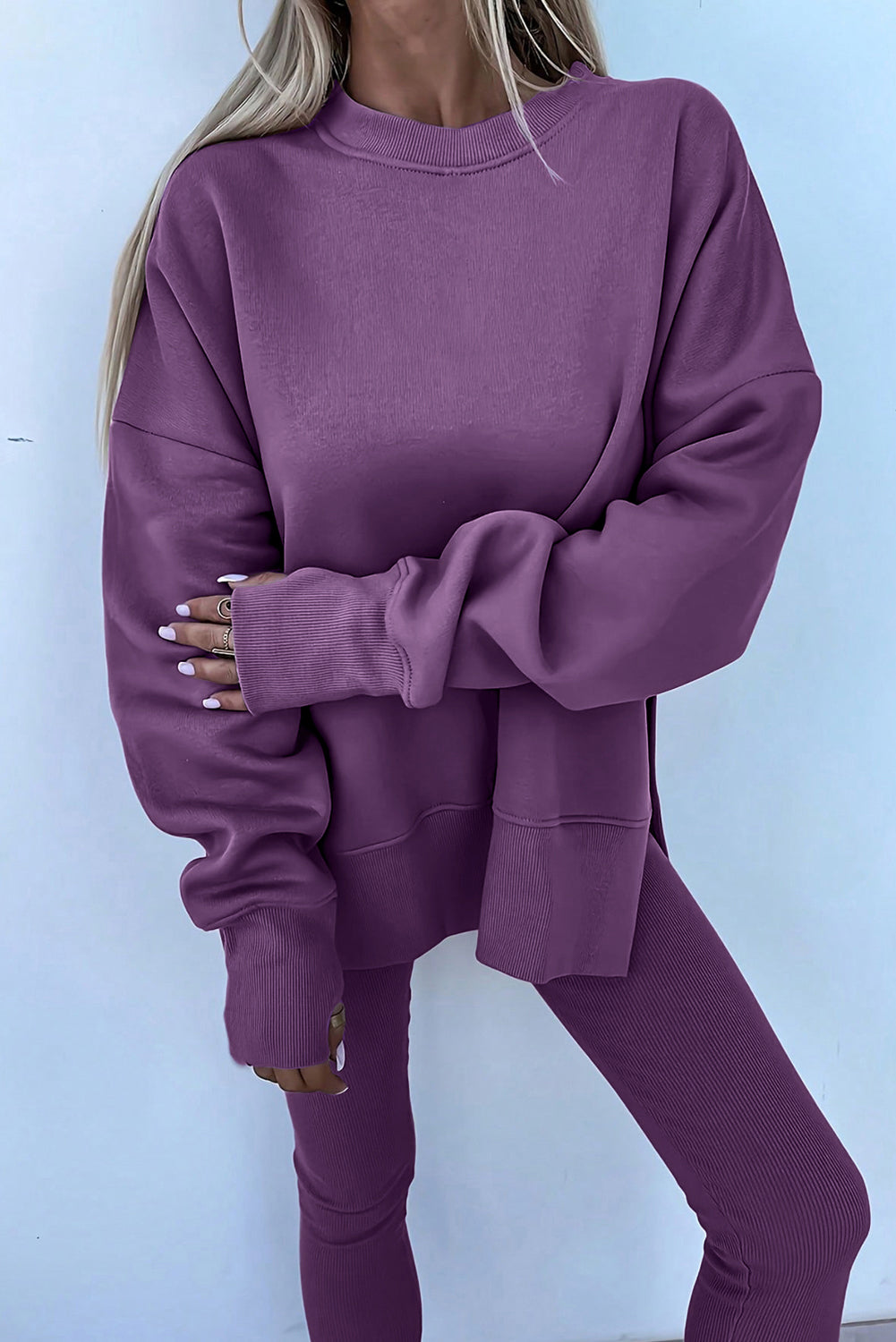 Person wearing a purple sweatshirt and pants against a light blue background