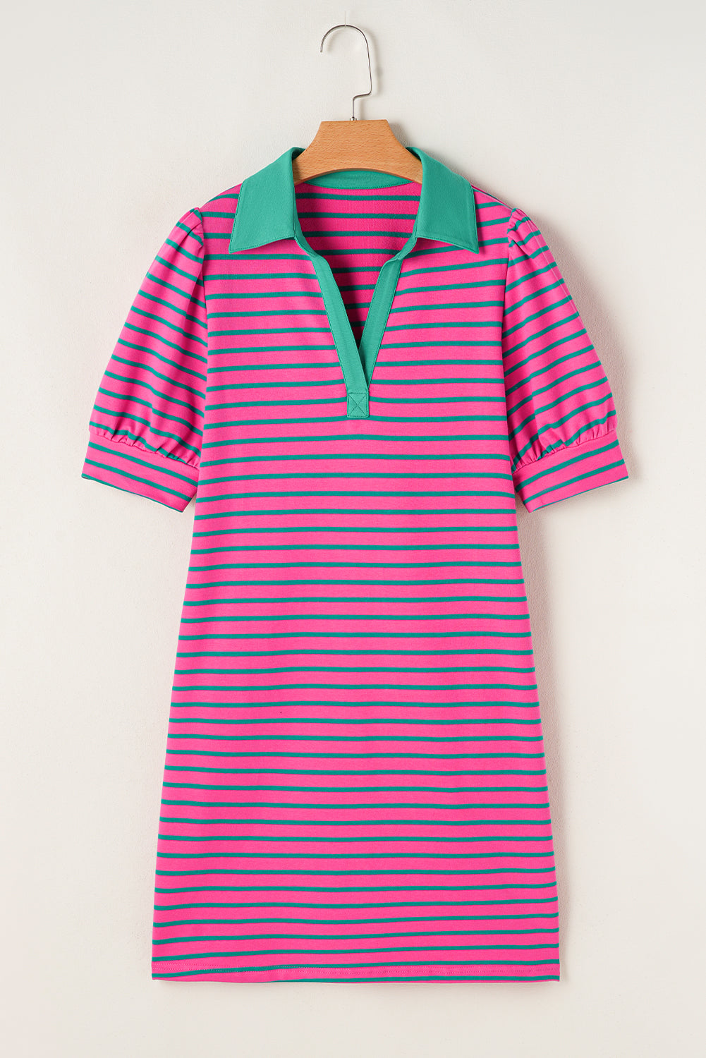 Pink and green striped dress on a hanger against a white background