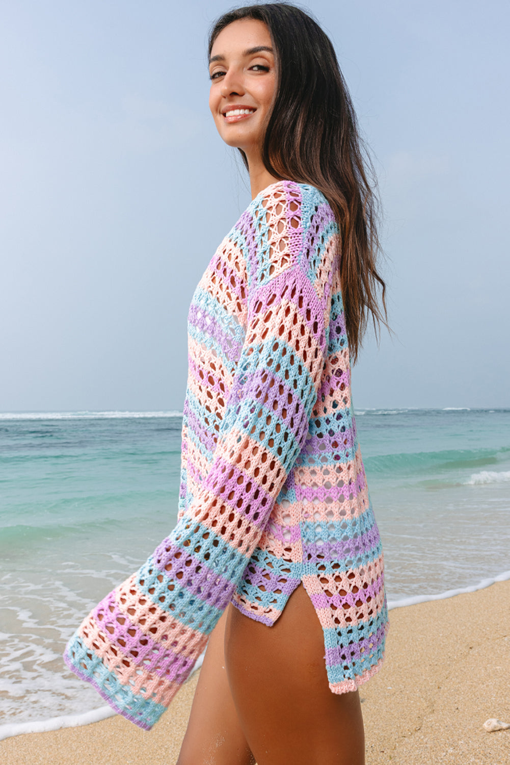 Woman wearing a colorful crochet cover-up on a beach
