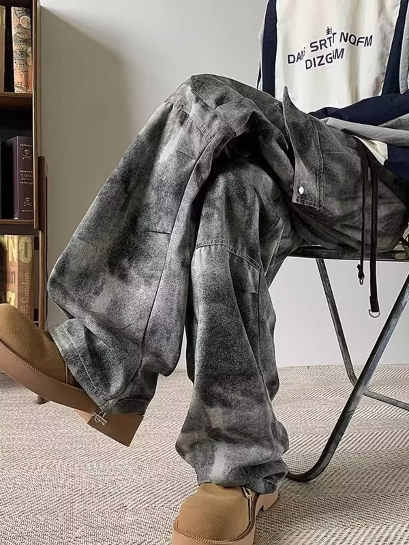Model wearing black/grey Men's Tie-dye Loose Fit Cargo Jeans in a chair
