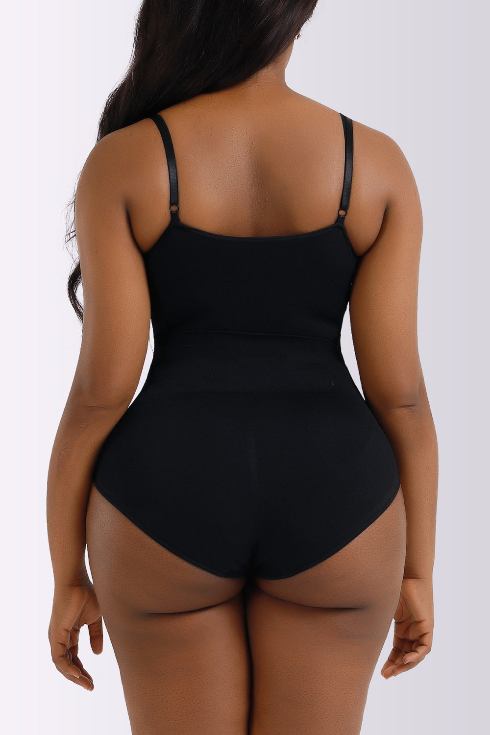 Person wearing a black bodysuit against a white background