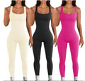 Three women wearing sleeveless jumpsuits in beige, black, and pink.