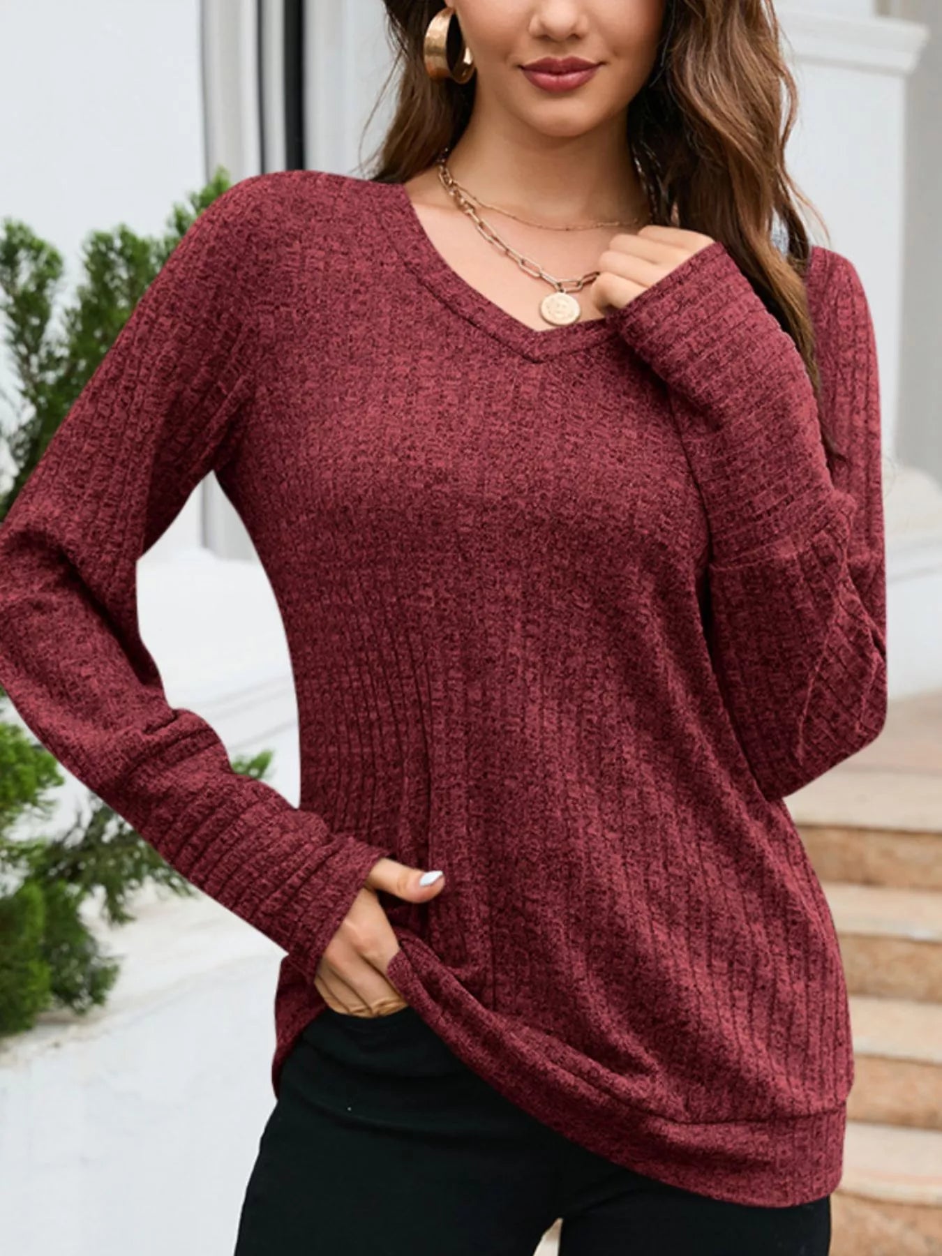 Woman wearing a maroon sweater with a blurred background