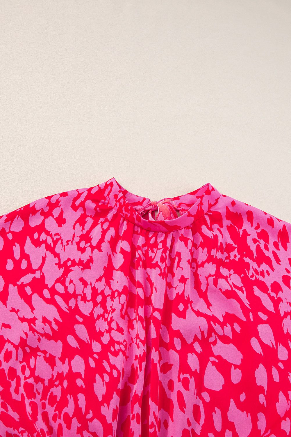 Pink patterned fabric on a beige background