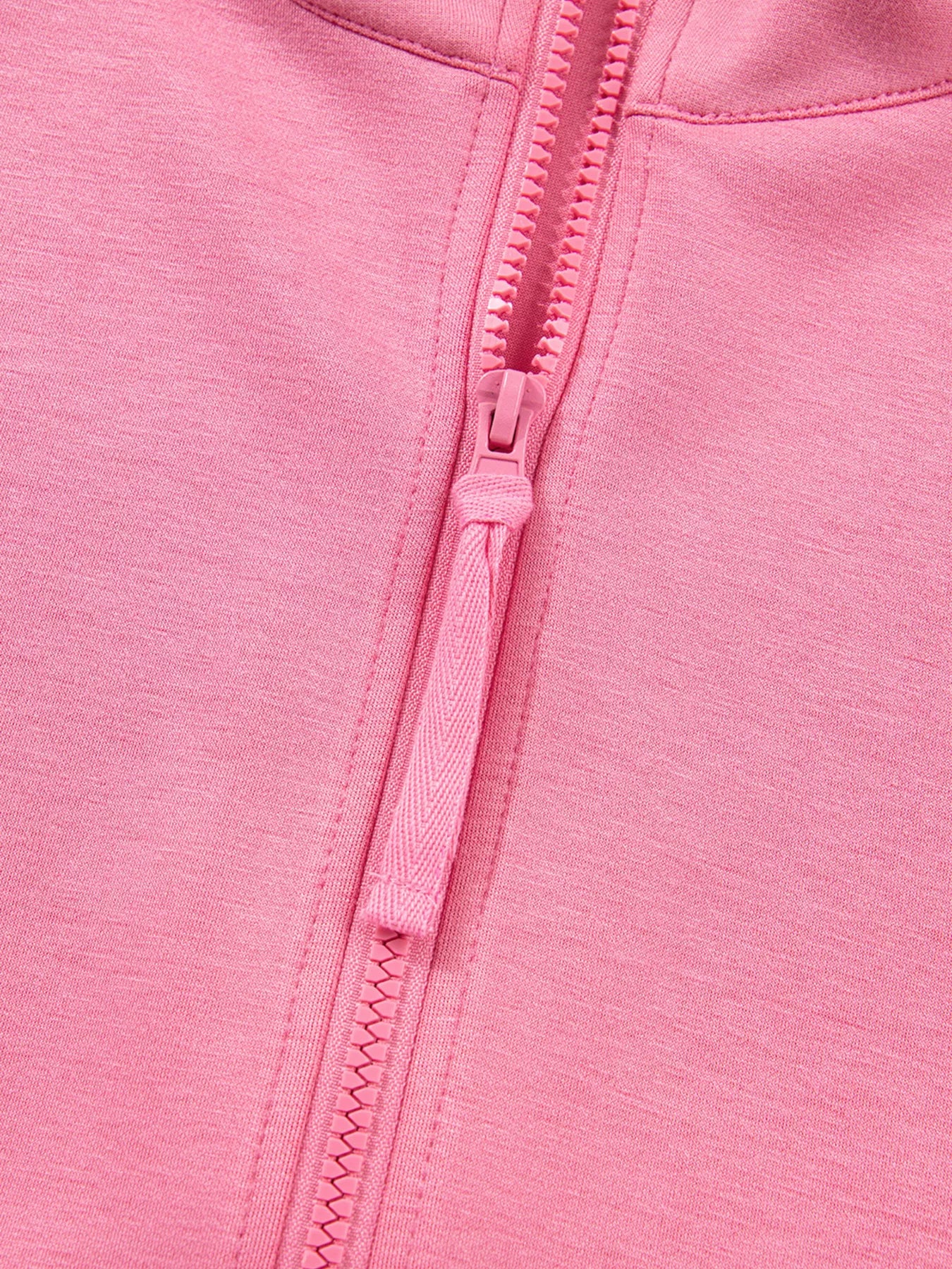 Close-up of a pink zipper on a pink fabric background