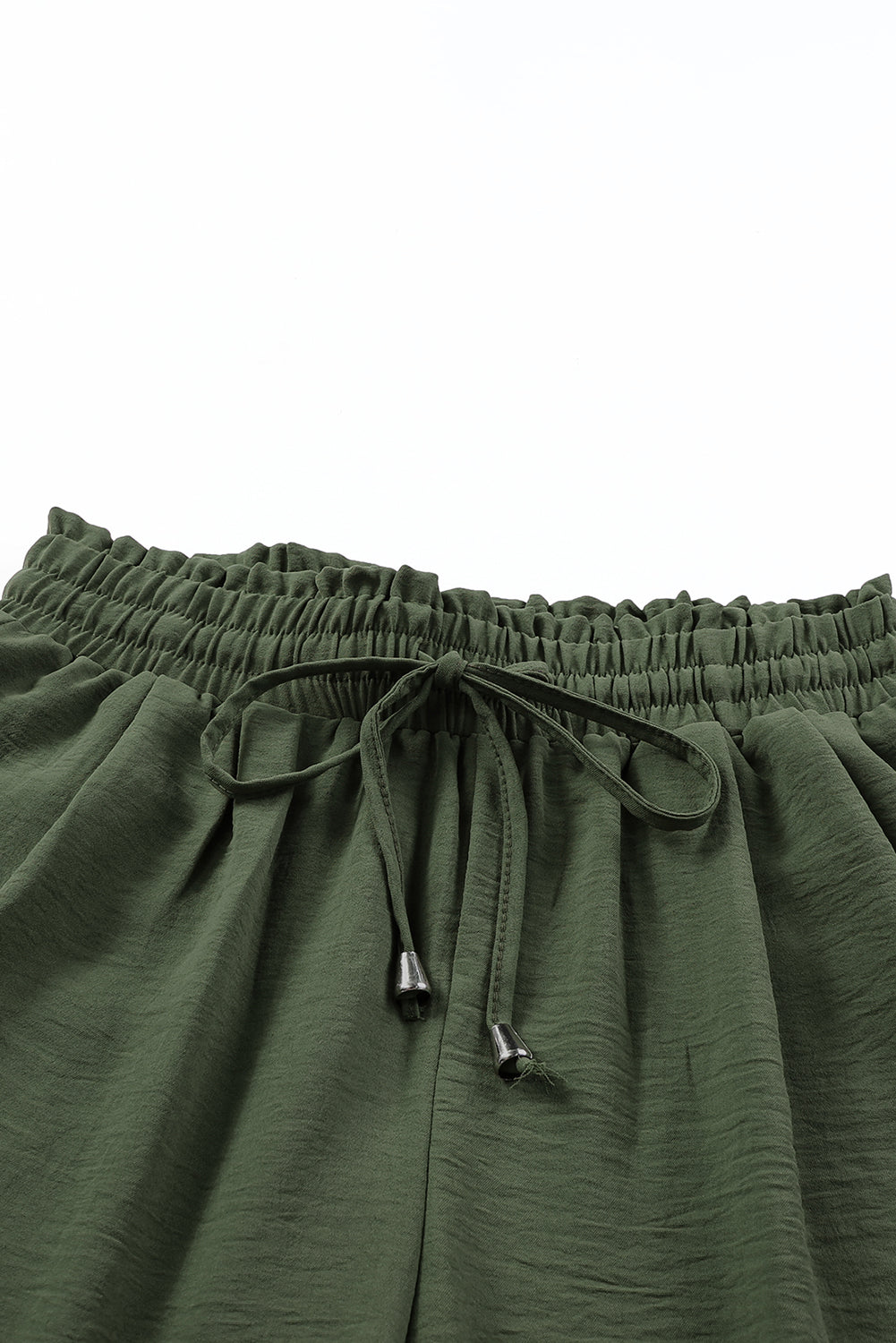 Green pants with drawstring waist close-up on a white background