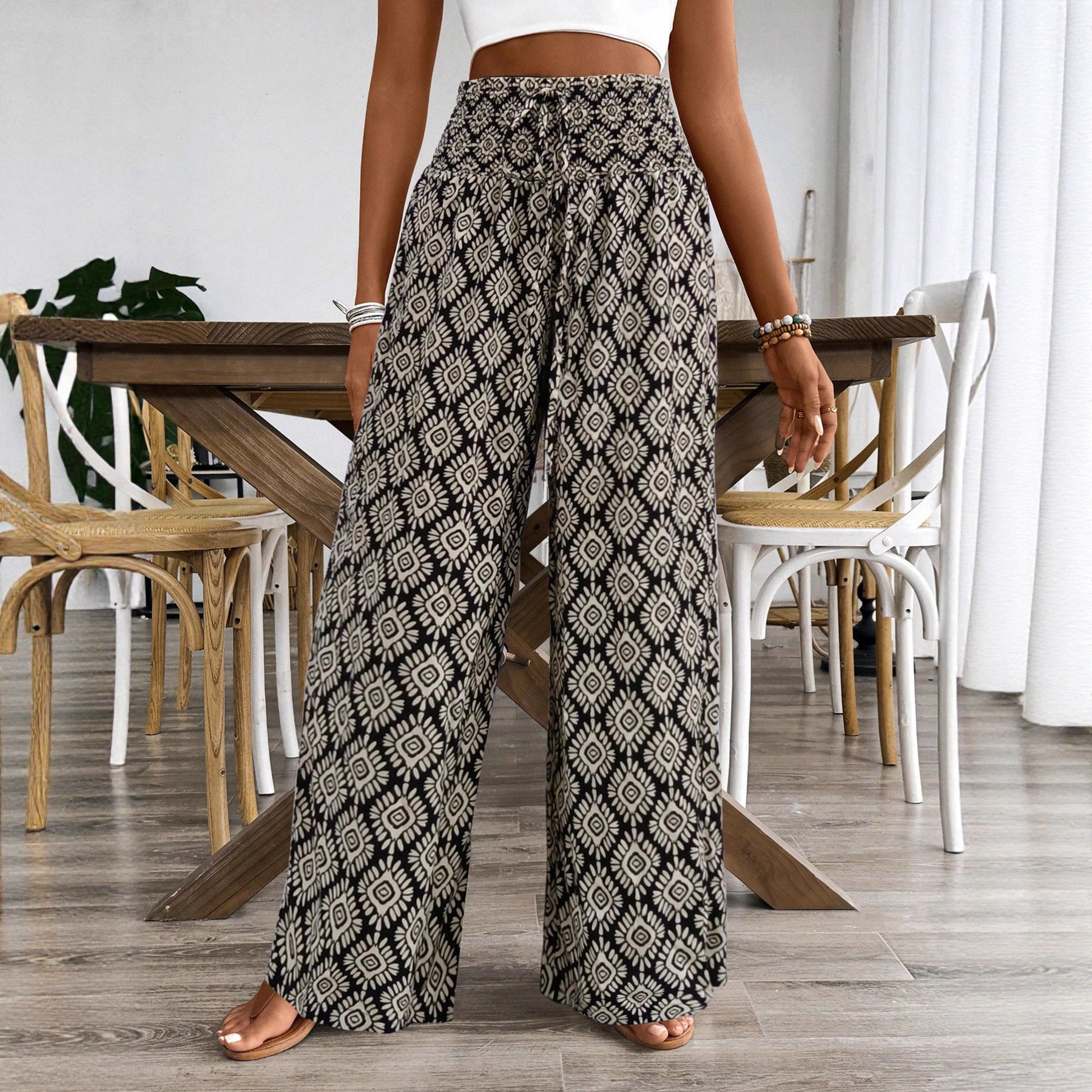 Person wearing patterned wide-leg pants in a dining room setting