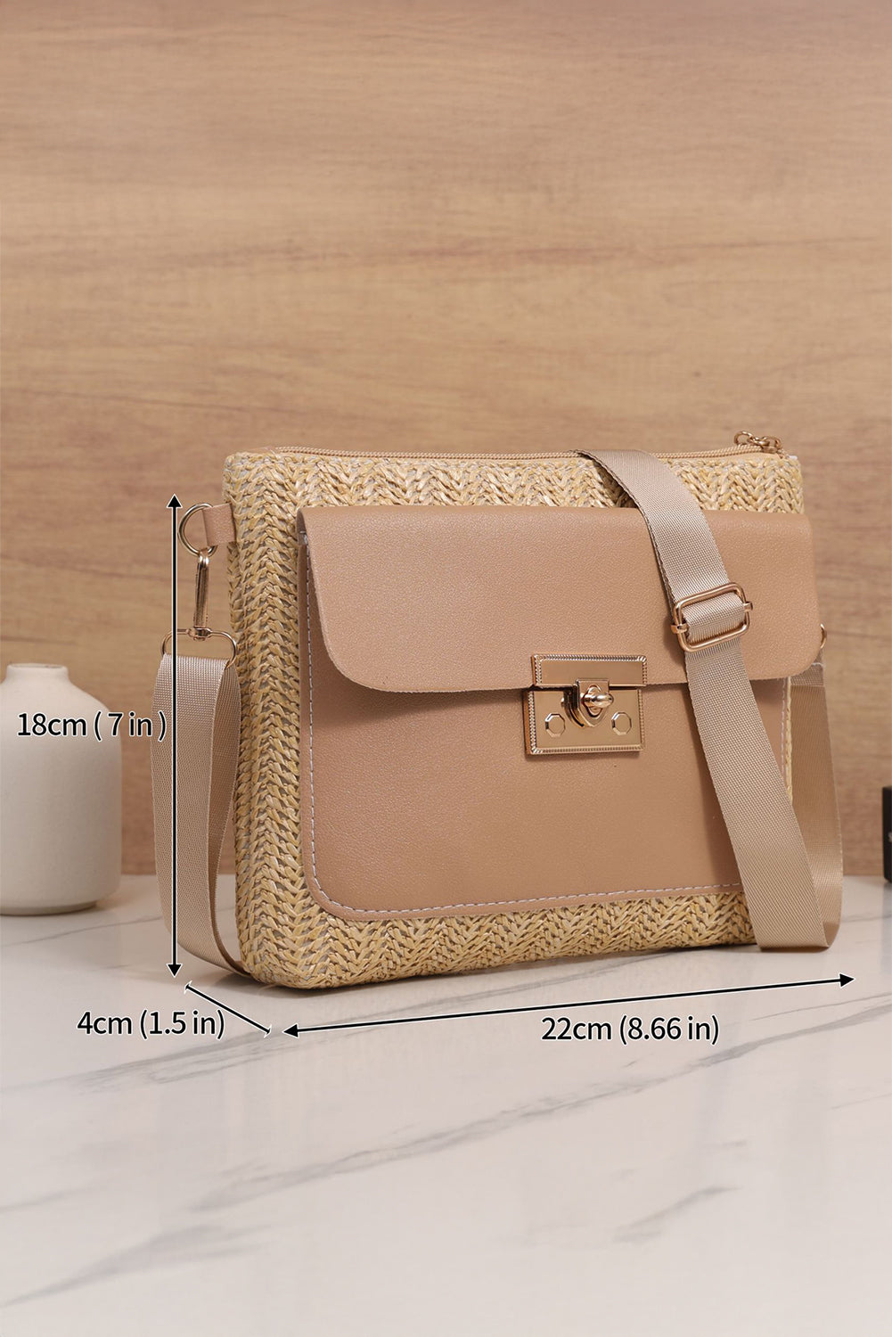 Beige handbag with wicker detailing and dimensions on a wooden surface