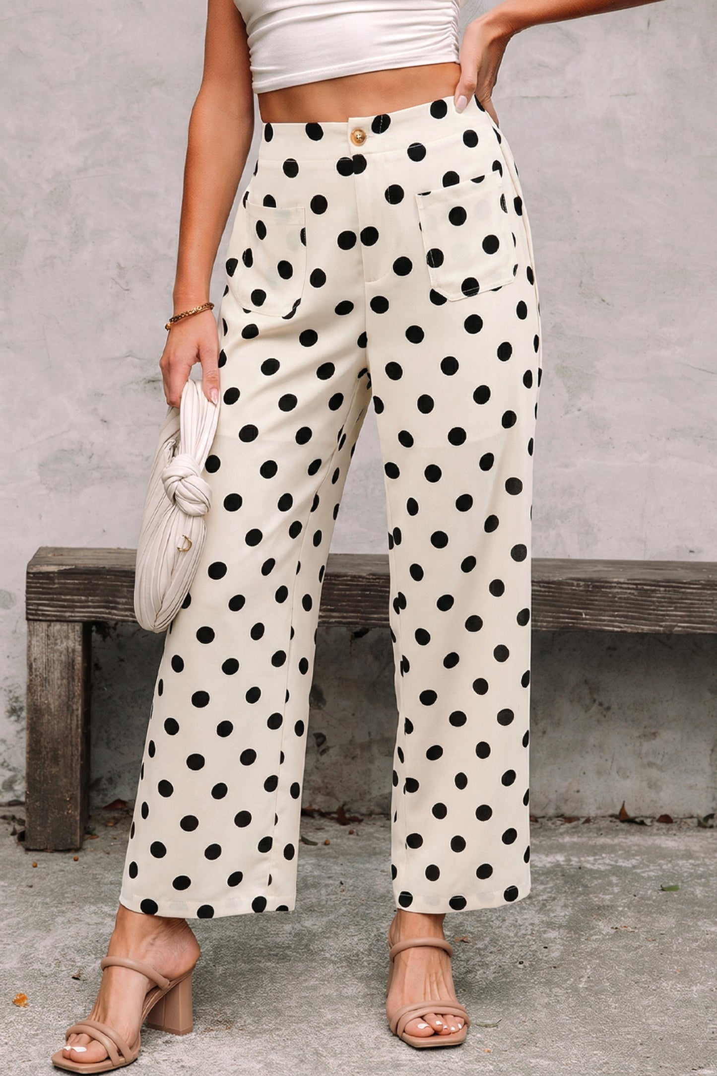 Person wearing polka dot white-black pants with a plain background