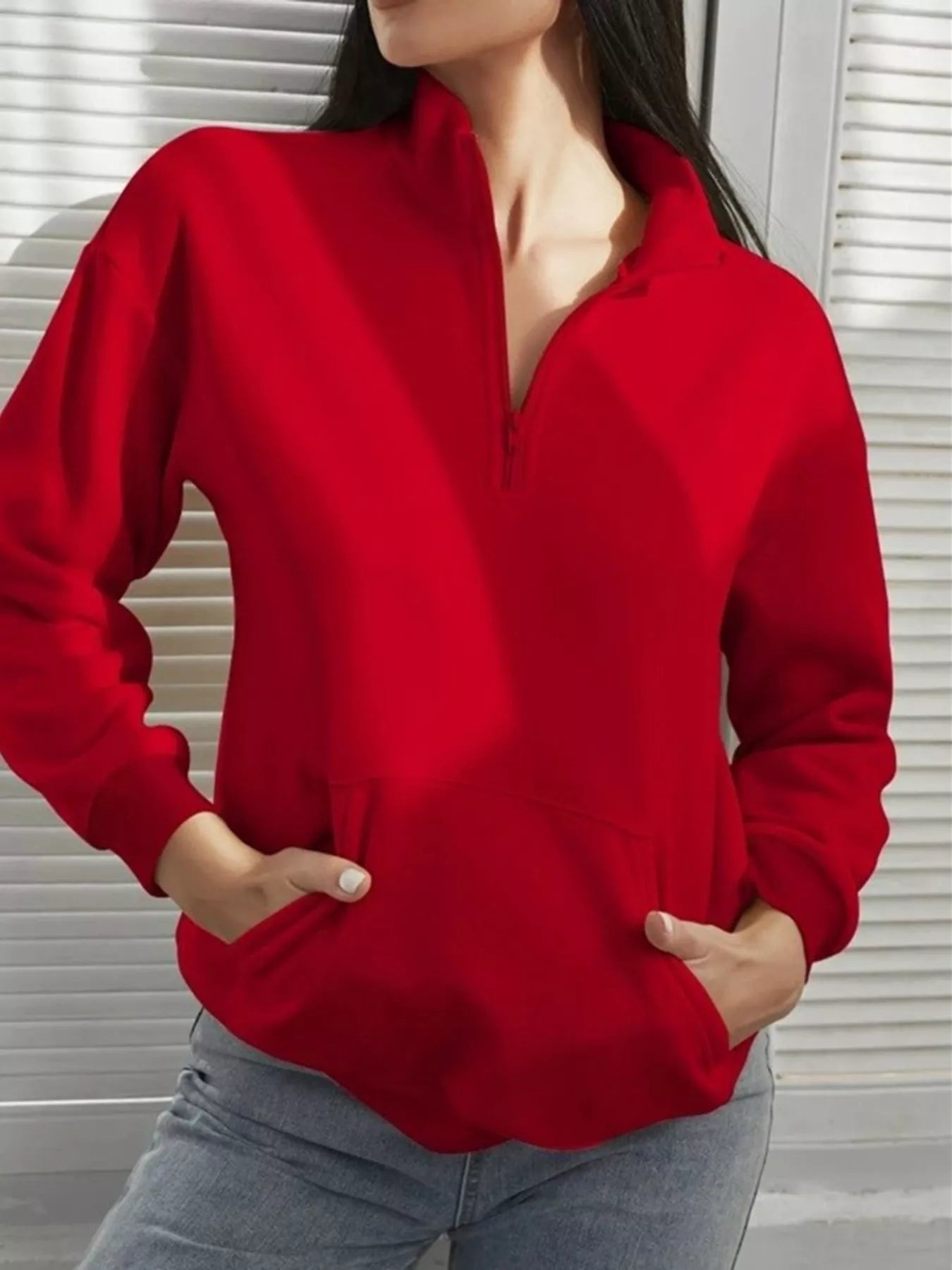 Person wearing a red sweater with a neutral background