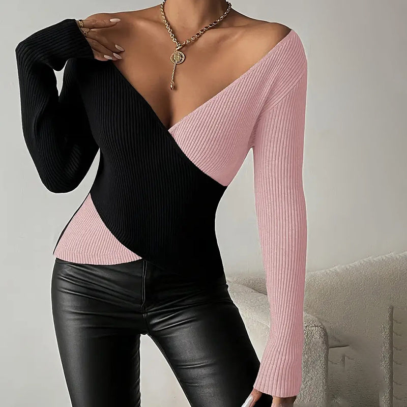 Black and pink long-sleeve top worn by a person, sitting on a gray couch.