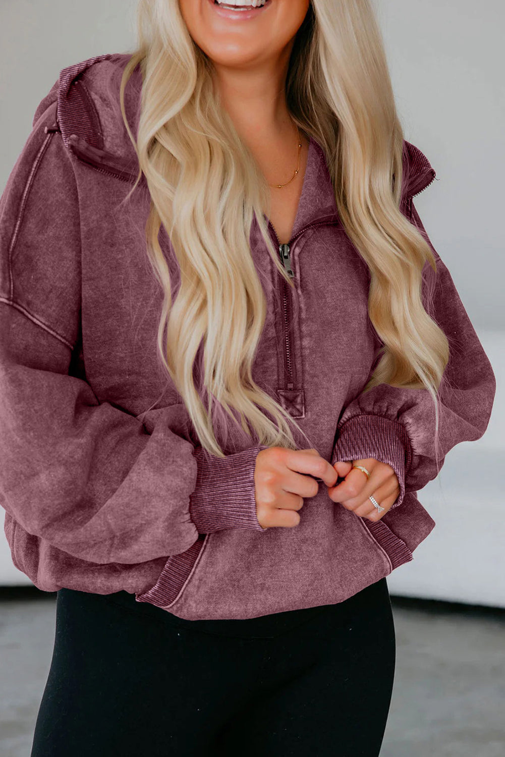 Woman wearing a maroon hoodie with a blurred background