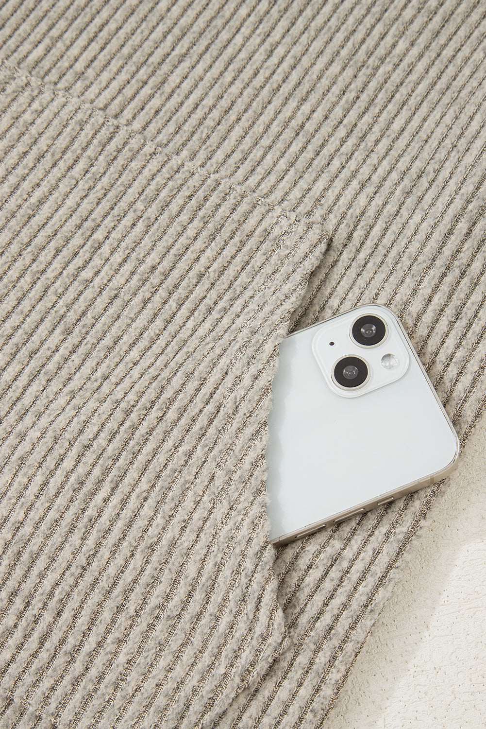 White smartphone on a textured beige surface