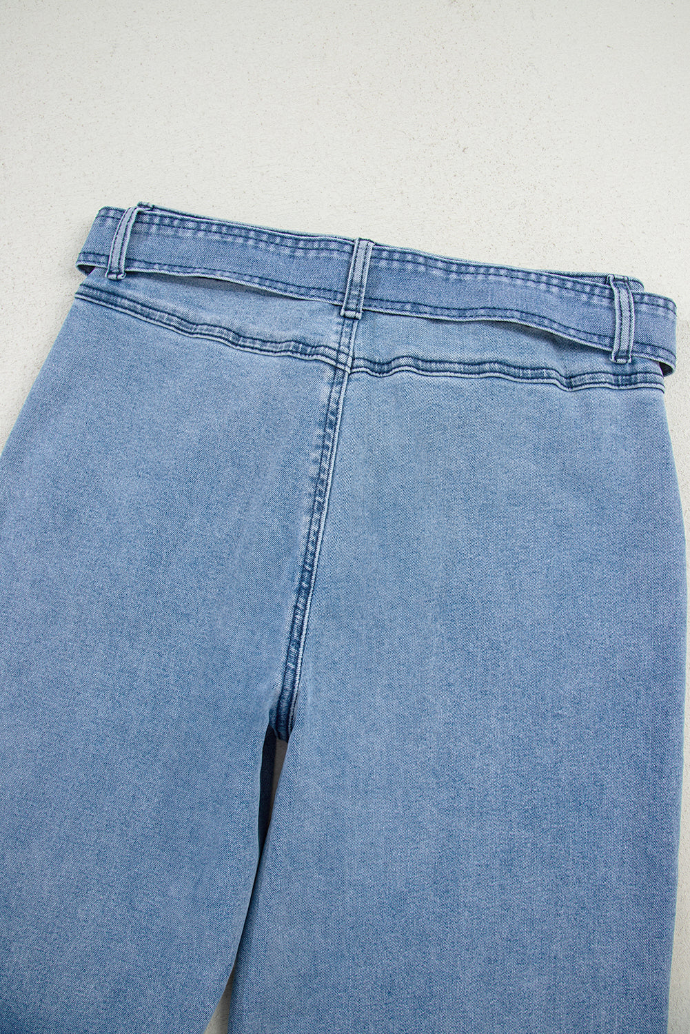 Light blue jeans on a light gray background