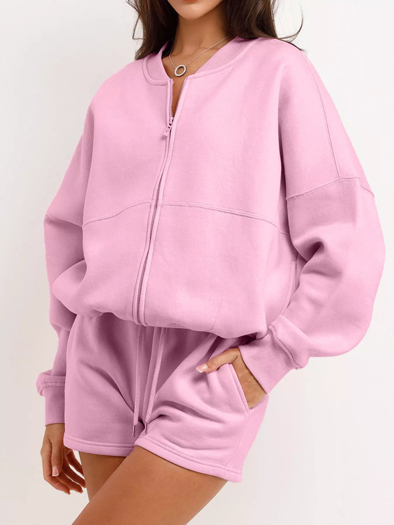 Pink tracksuit worn by a person on a white background