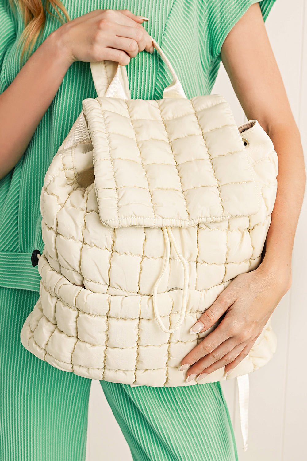 Model holding a Chic white Quilted Puffer Flap Backpack 