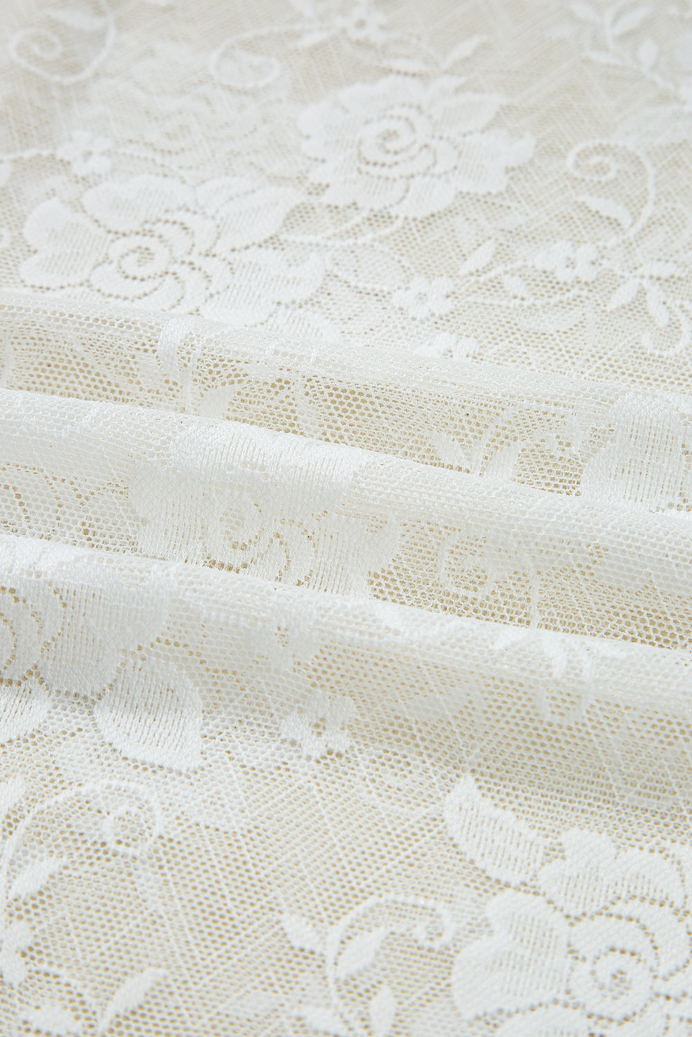Close-up of white lace fabric with floral patterns