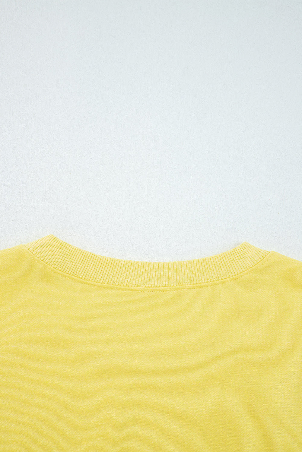 Yellow sweatshirt collar on a light gray background