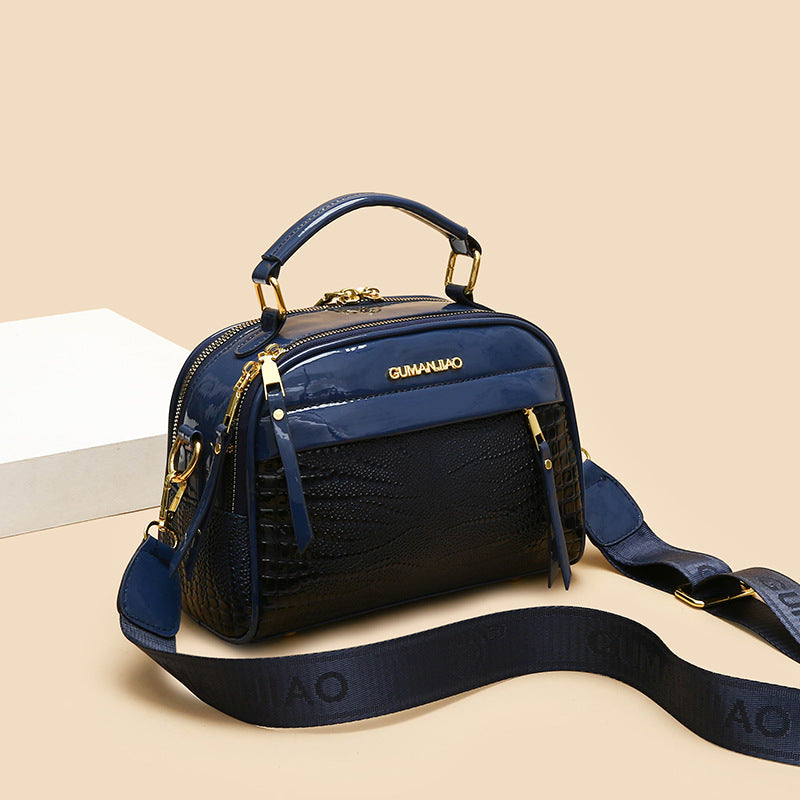 Blue handbag with gold accents on a beige background