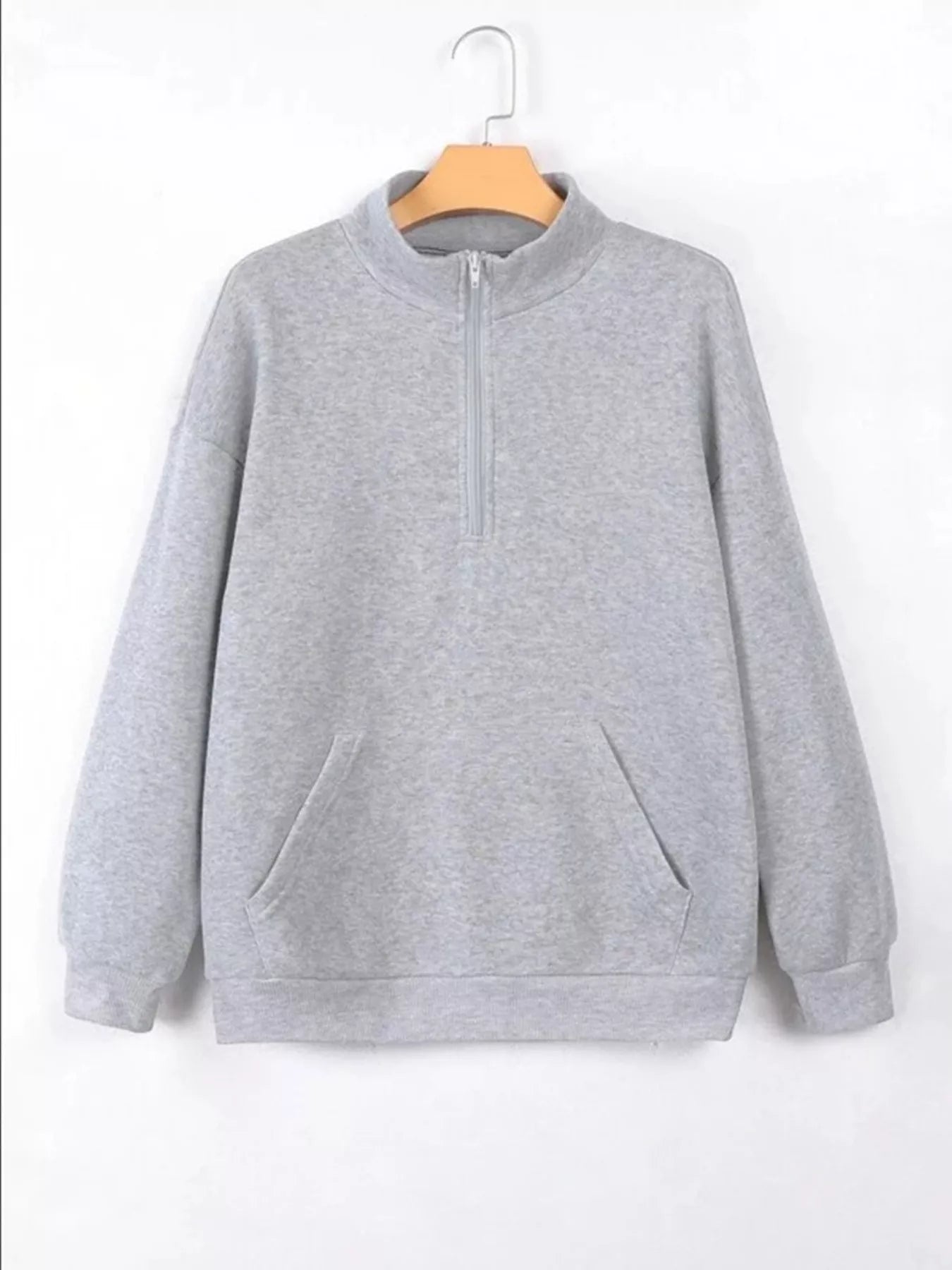 Gray sweatshirt on a wooden hanger against a white background