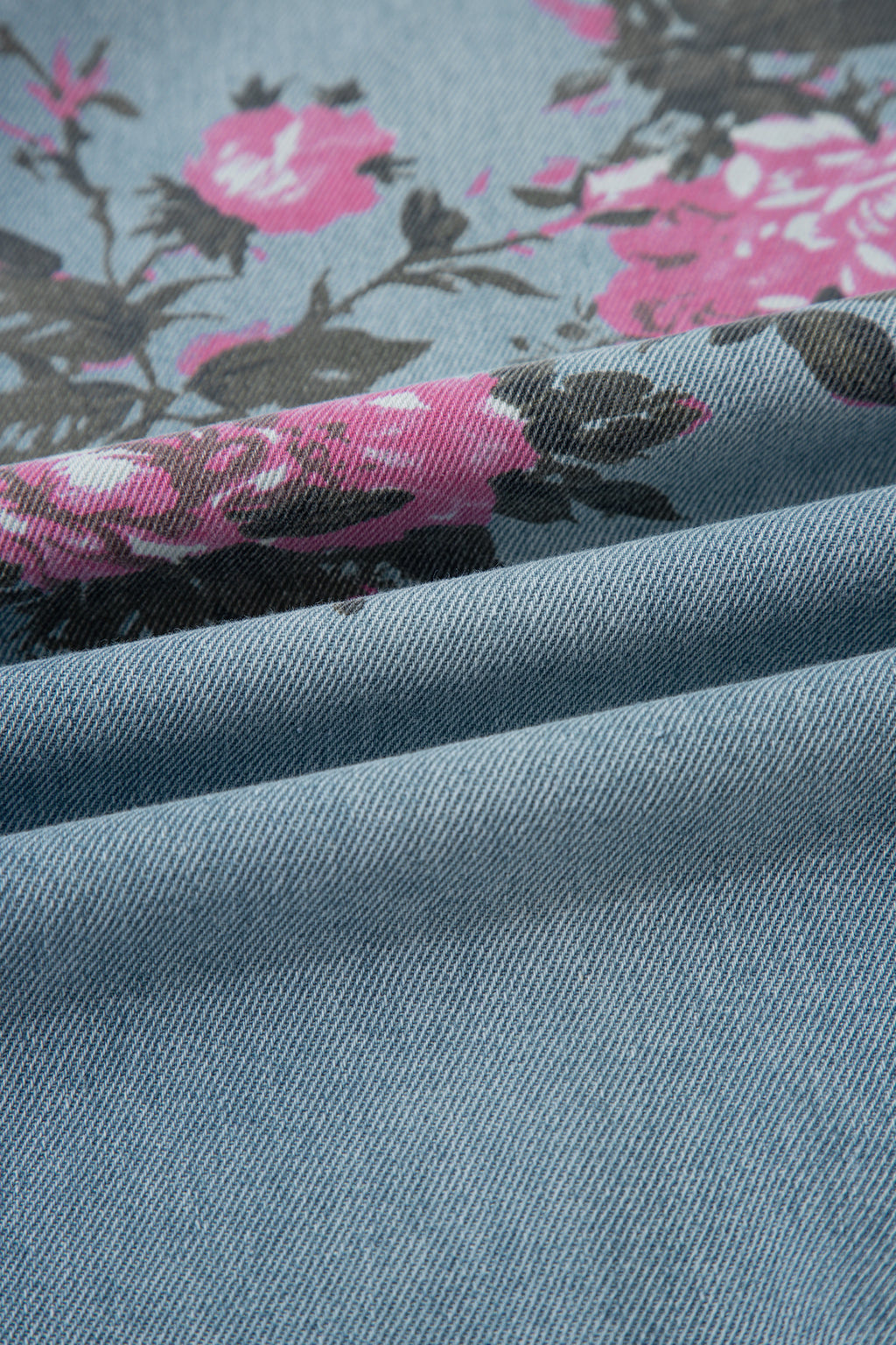 Close-up of blue fabric with pink floral pattern