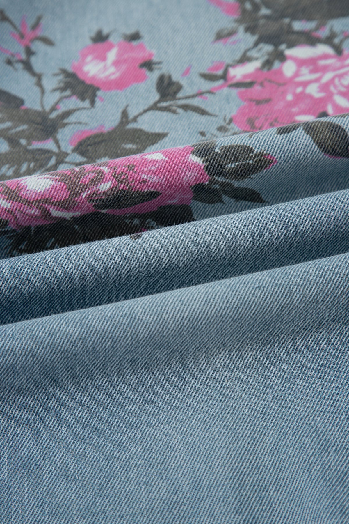 Close-up of blue fabric with pink floral pattern