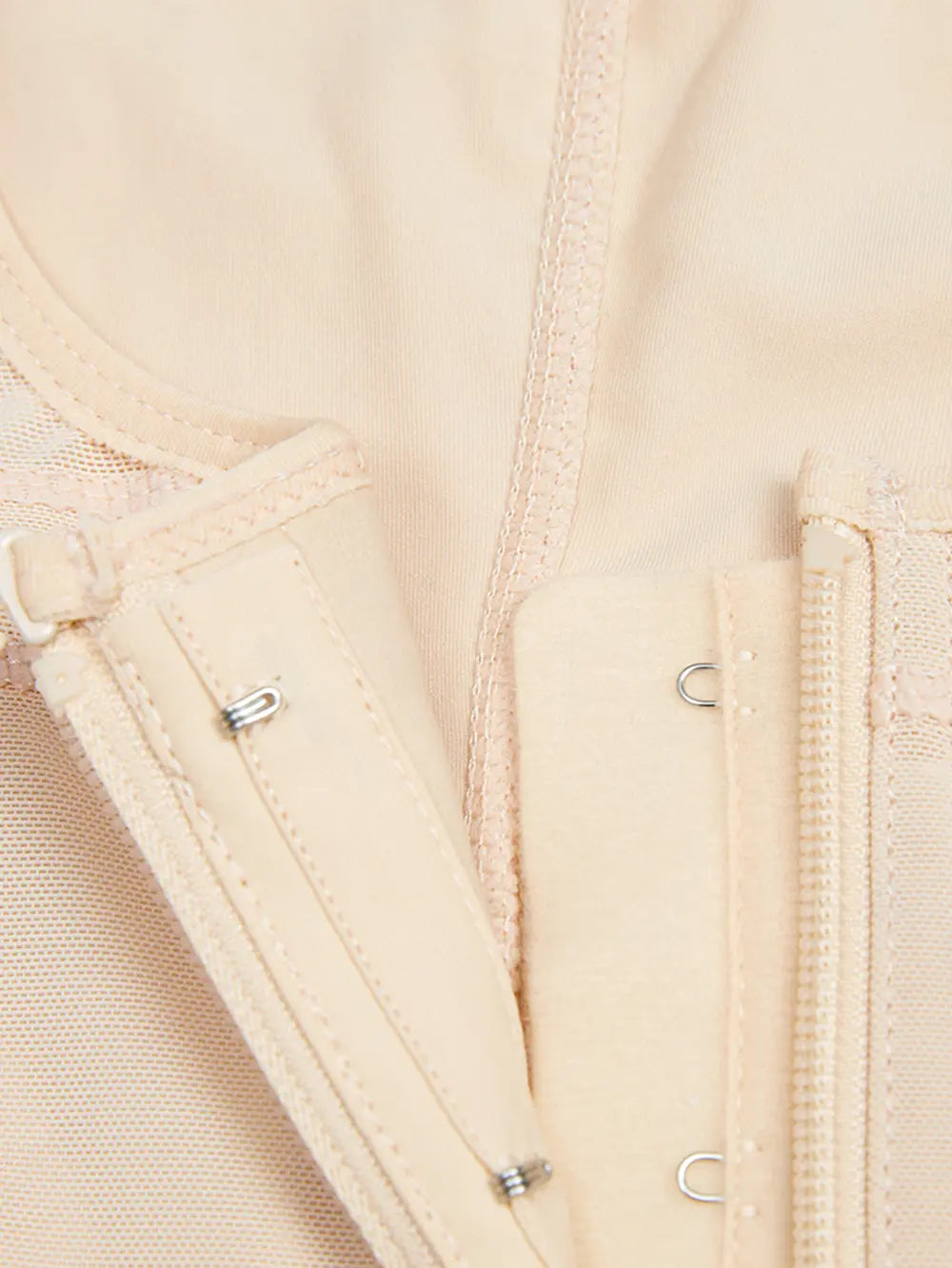 Close-up of a beige jacket with zippers and buttons