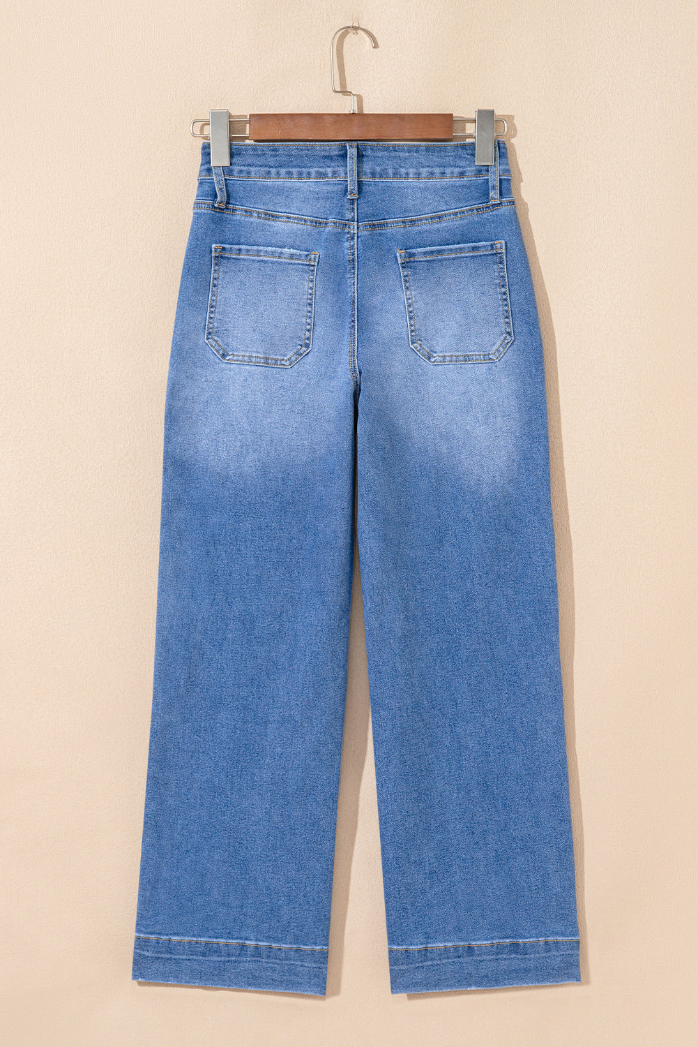 Blue jeans hanging on a beige background