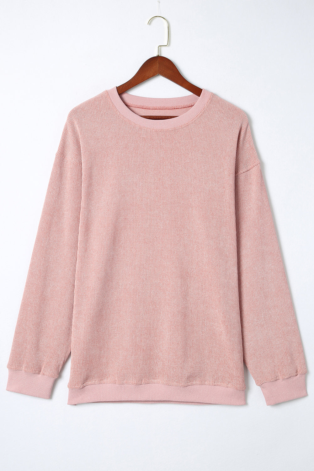 Pink sweatshirt on a wooden hanger against a white background