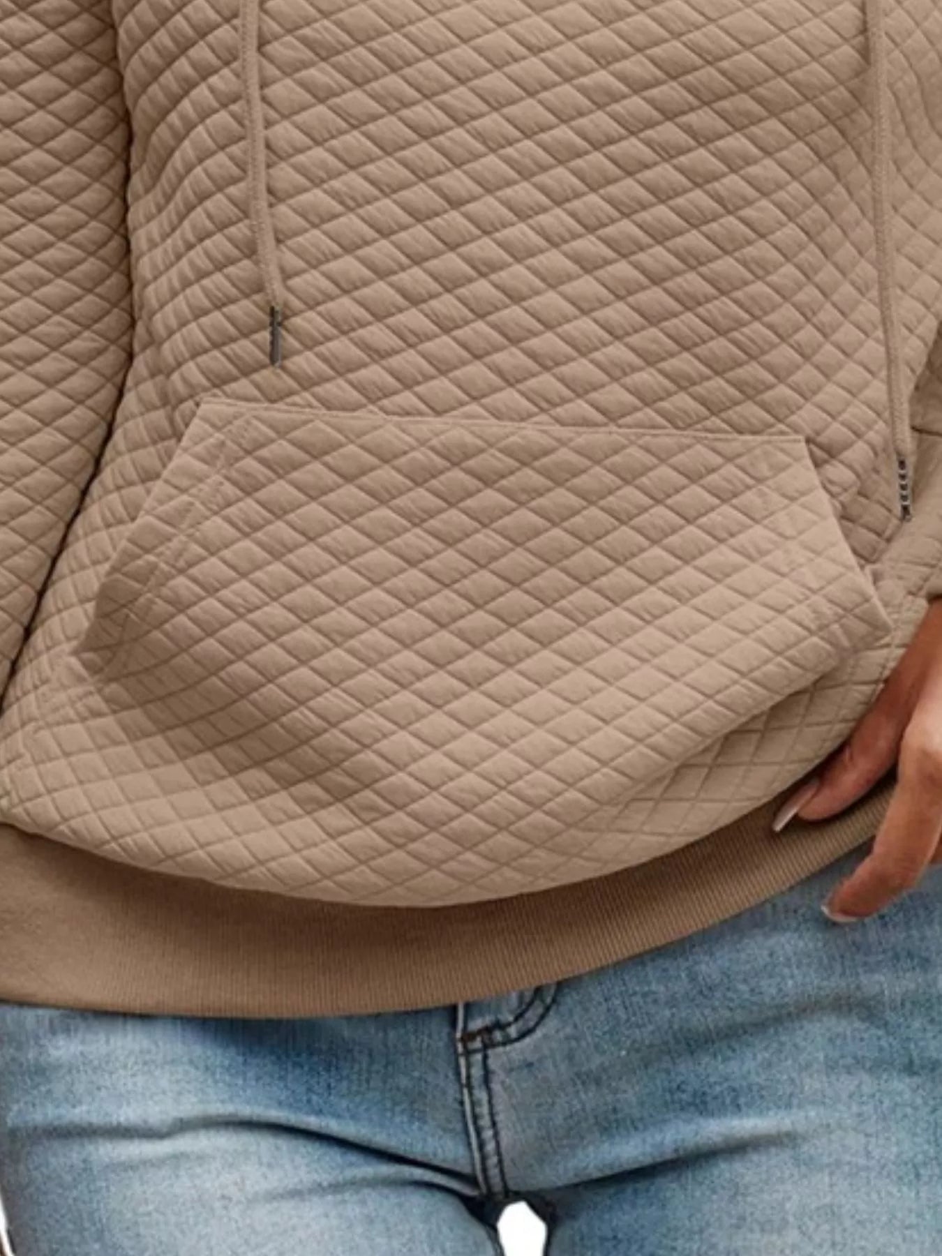 Beige quilted jacket worn by a person with blue jeans