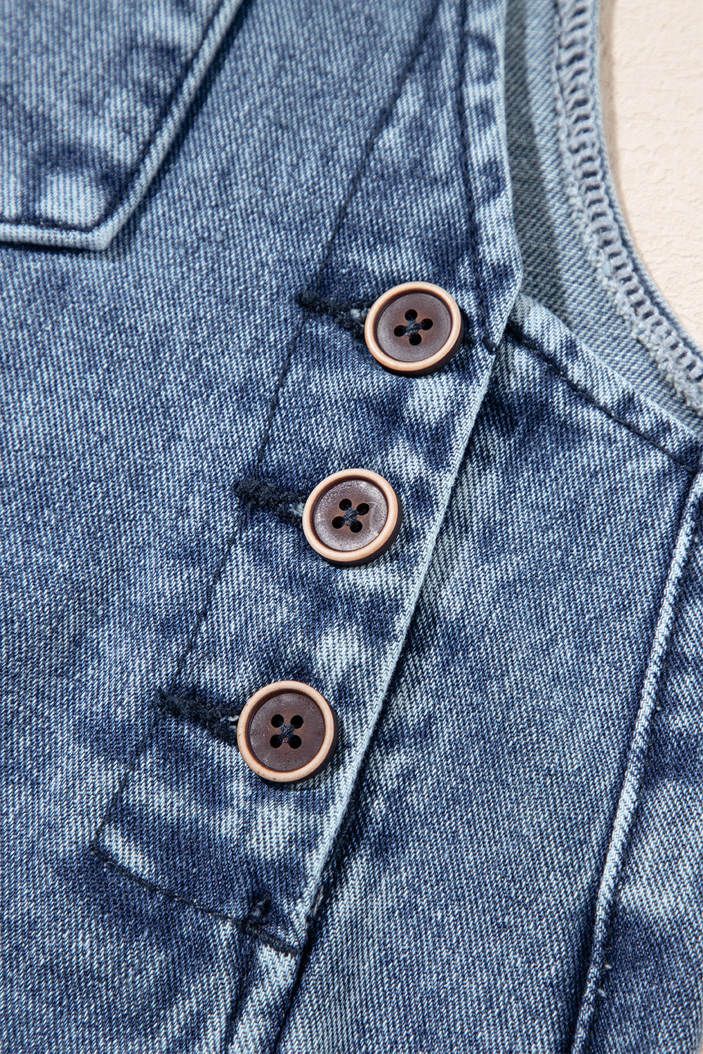 Close-up of a denim garment with button details