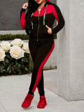 Person wearing a black and red outfit with white roses in the background